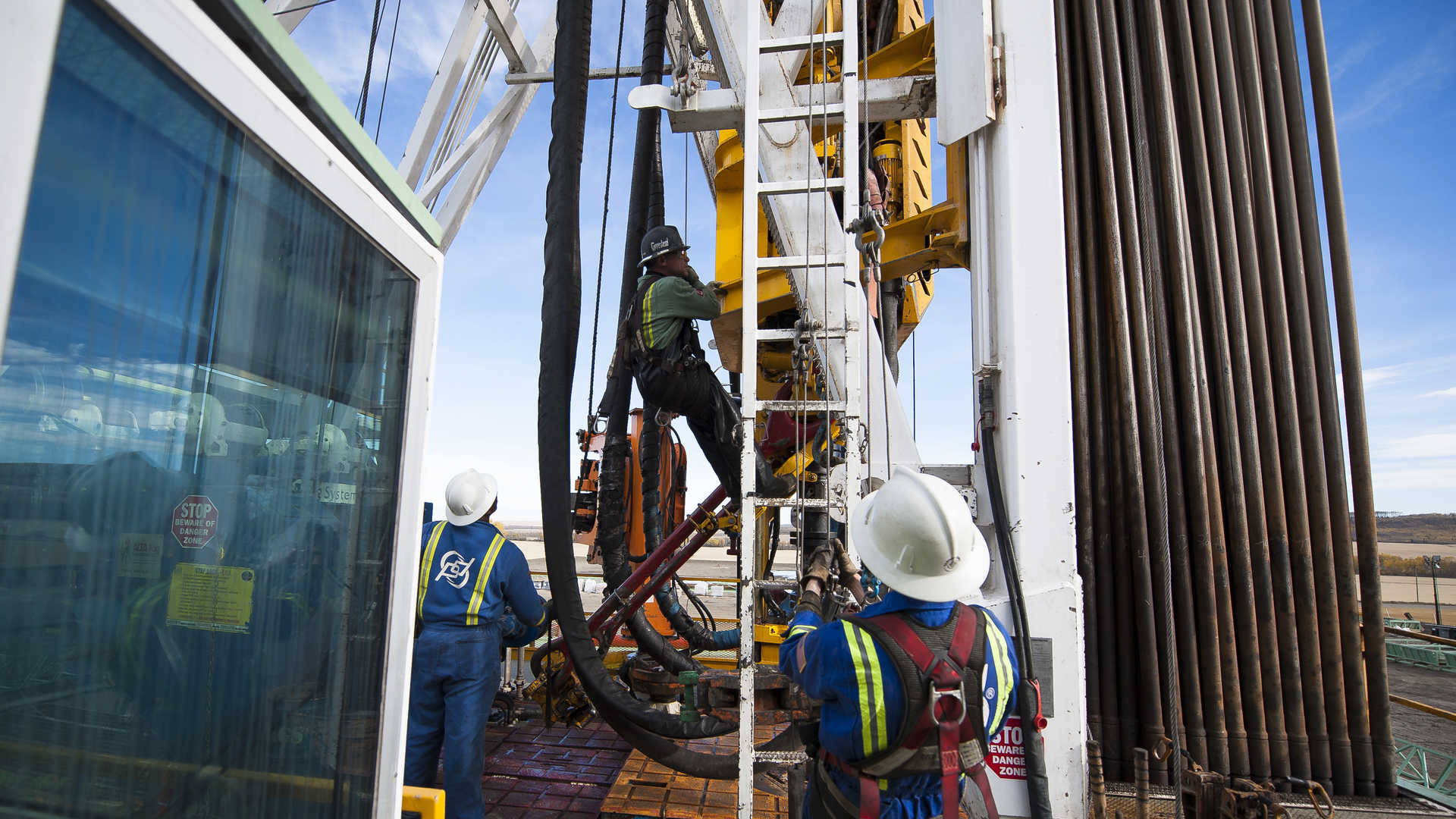 Oil Workers Climb a Rig