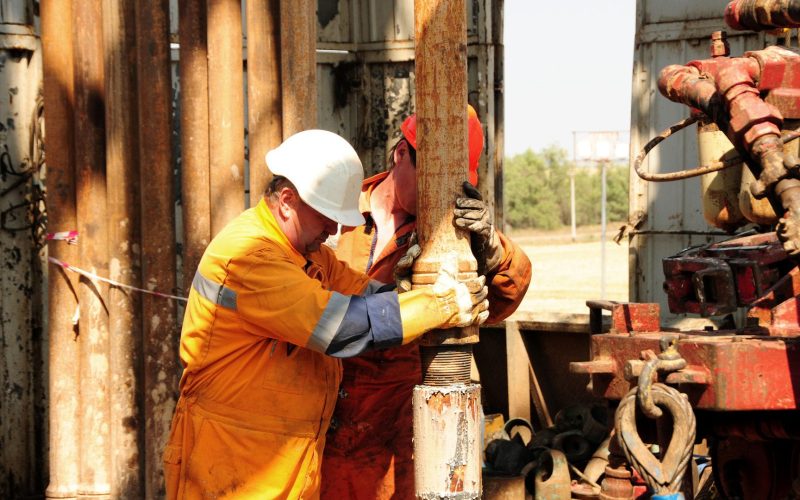 Drilling rig workers in orange uniform